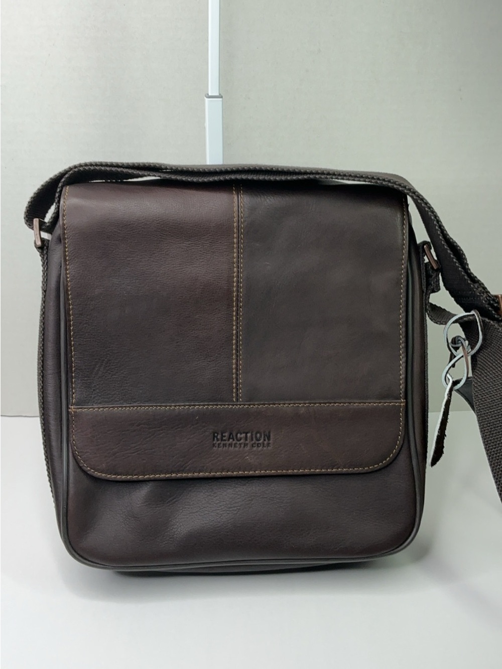 Kenneth Cole Reaction dark brown leather messenger-style tablet bag.